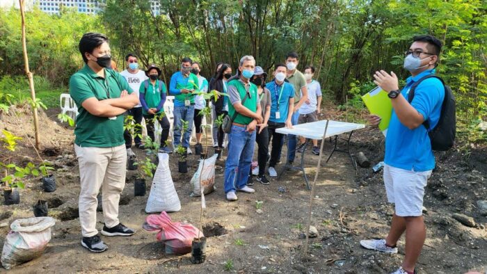 A briefing on site before planting begins, with sacks of seedlings waiting at the edge of the plot